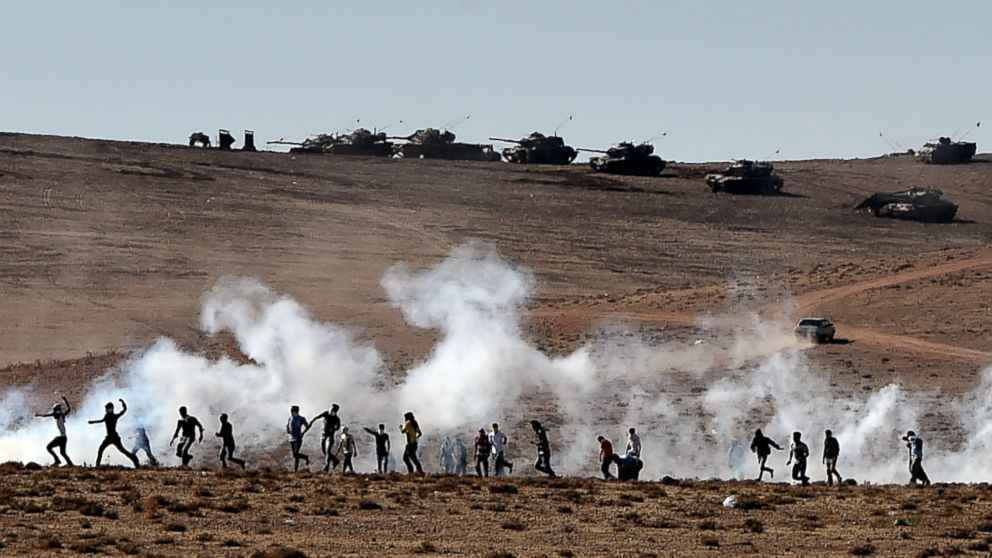 PHOTO: Kurdish people throw stones at Turkish armored vehicles near the Syrian town known as Kobane by the Kurds, in the southeastern town of Suruc, Sanliurfa province, Turkey, Oct. 7, 2014. 