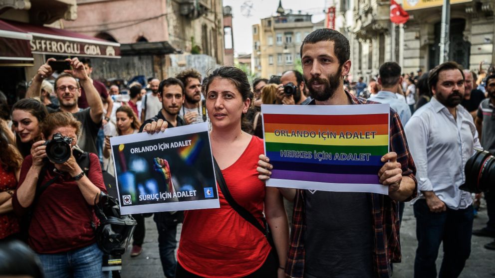 People hold signs reading 'Justice for Orlando' during a rally staged by the LGBT community on Istiklal Avenue in Istanbul on June 19, 2016.