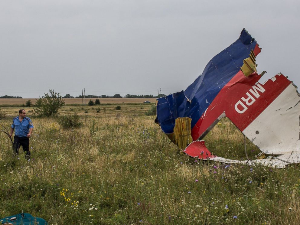 PHOTO: A Ukrainian police officer searches for human remains from Malaysia Airlines Flight 17 on July 18, 2014 in Grabovka, Ukraine.