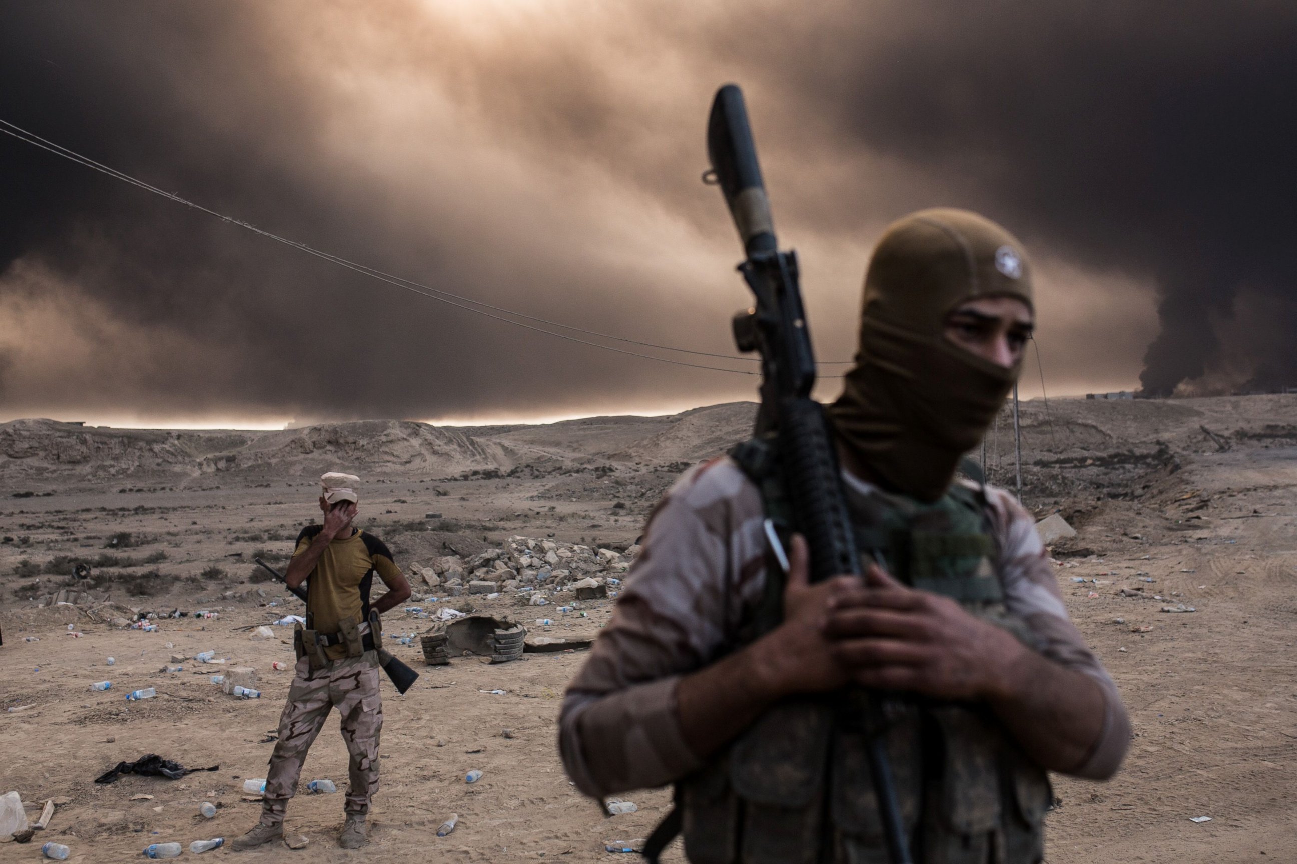 PHOTO: Iraqi soldiers look on as smoke rises from the Qayyarah area, some 60 kilometers (35 miles) south of Mosul, October 19, 2016.