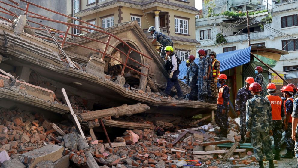 PHOTO: U.S. rescue team officials with a sniffer dog search for survivors at a collapsed house in Kathmandu on May 12, 2015, after an earthquake struck.