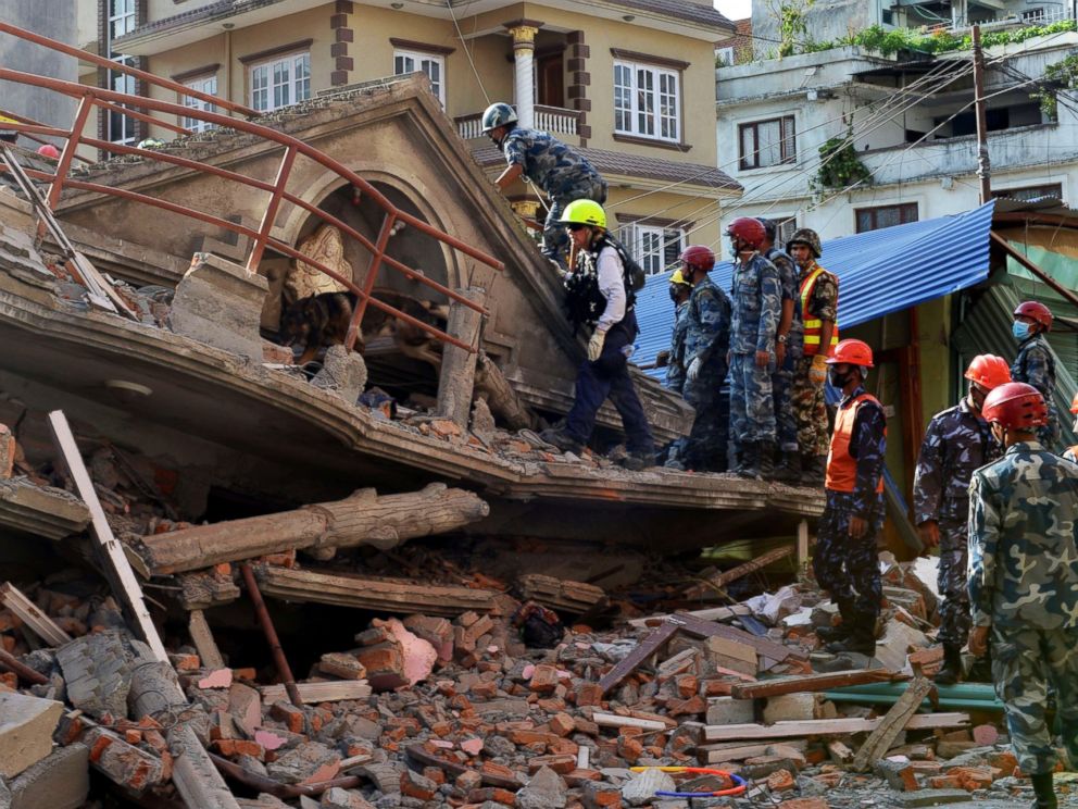 PHOTO: U.S. rescue team officials with a sniffer dog search for survivors at a collapsed house in Kathmandu on May 12, 2015, after an earthquake struck.