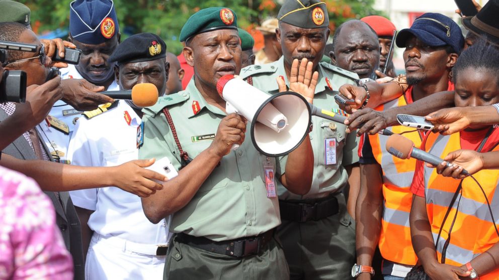 Nigerian Defense spokesman Major General Chris Olukolade, center, speaks to civil society groups protesting the abduction of hundreds of girls during a rally pressing for the girls' release in Abuja, May 6, 2014.