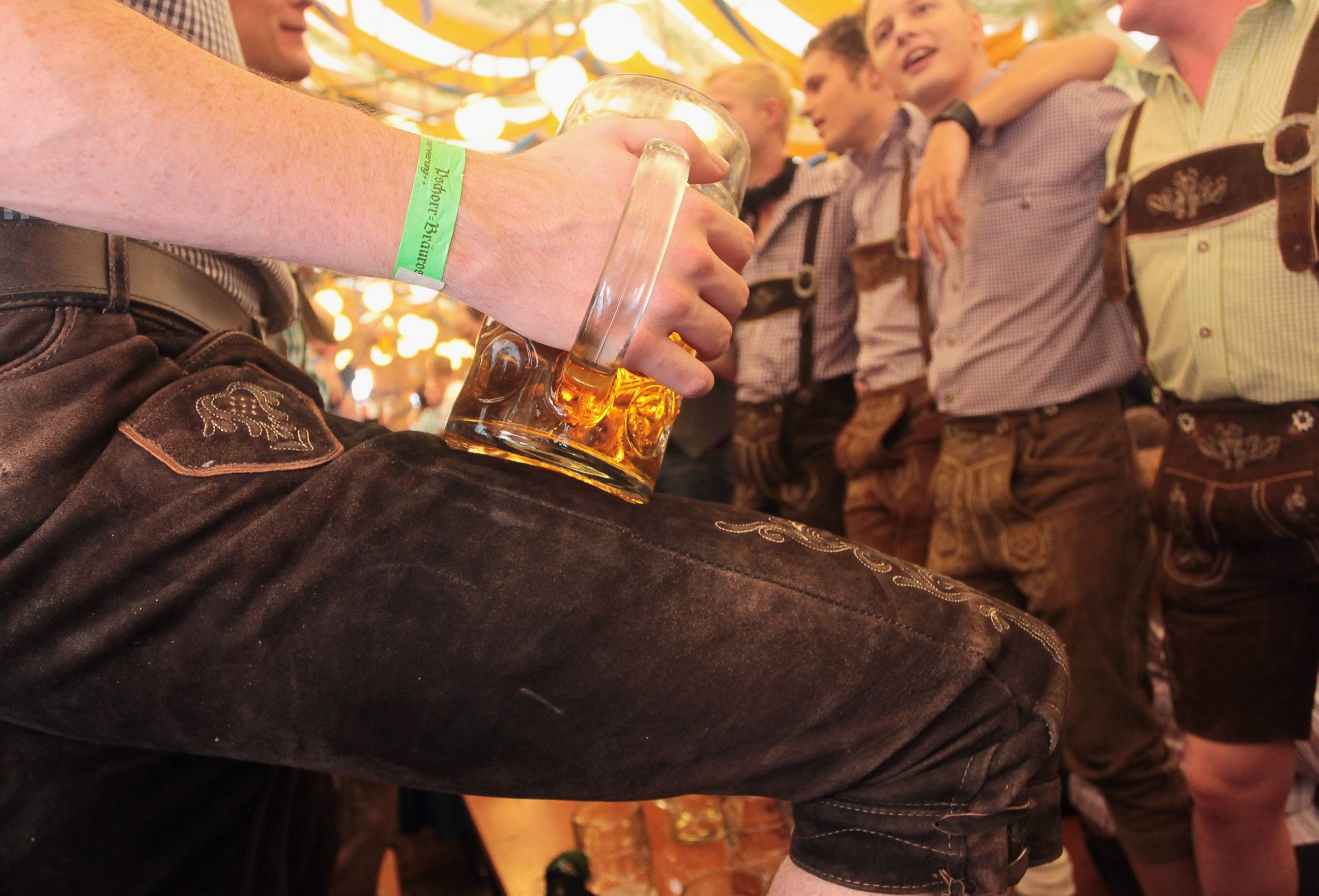 PHOTO: Revellers dressed with traditional Bavarian Lederhosen trousers enjoy drinking beer