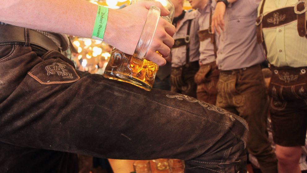PHOTO: Revellers dressed with traditional Bavarian Lederhosen trousers enjoy drinking beer