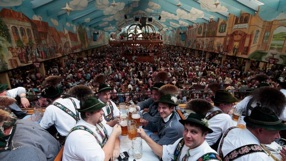 Visitors wearing traditional Bavarian clothes clink beer glasses in the Hacker-Pschorr tent at the Oktoberfest 2013 beer festival in Munich, Germany Sept. 22, 2013. 