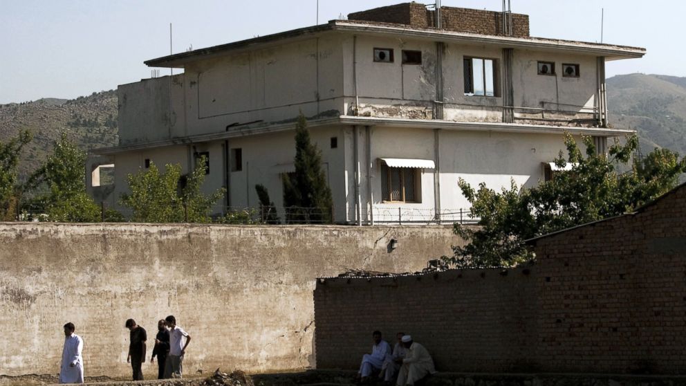 PHOTO: People walk past Osama Bin Laden's compound, May 3, 2011, in Abottabad, Pakistan. 