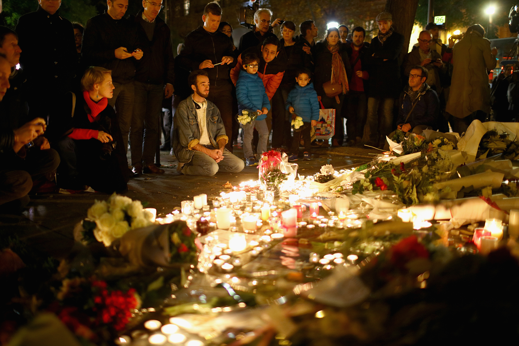 PHOTO: Flowers and candles are left on the pavement near the scene of yesterday's Bataclan Theater terrorist attacks, Nov. 14, 2015 in Paris.