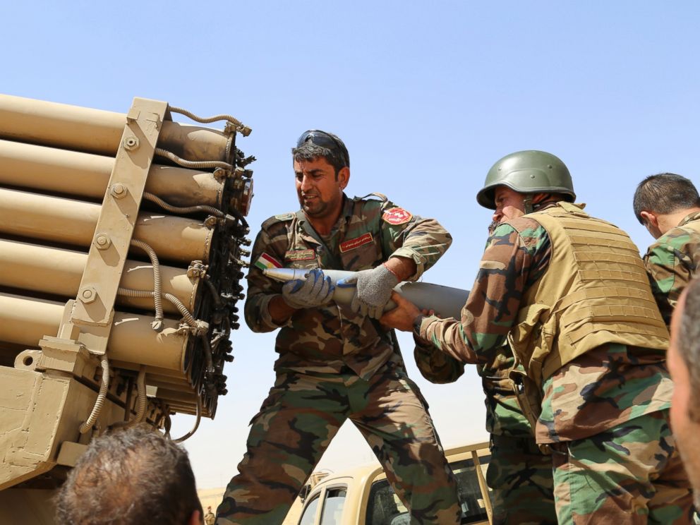 PHOTO: Kurdish peshmerga fighters load a missile launcher