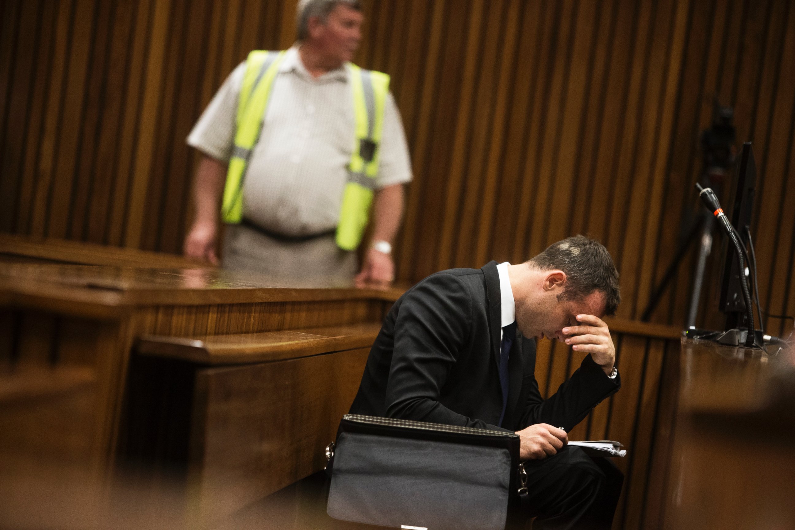 PHOTO: Oscar Pistorius looks at his notes during the fourth day of his trial for the murder of his girlfriend Reeva Steenkamp at the North Gauteng High Court in Pretoria, March 6, 2014.