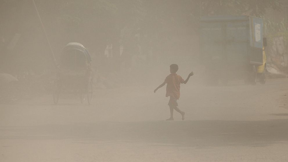 A Bangladeshi child walks along a dusty road in Dhaka, Sept. 27, 2016.