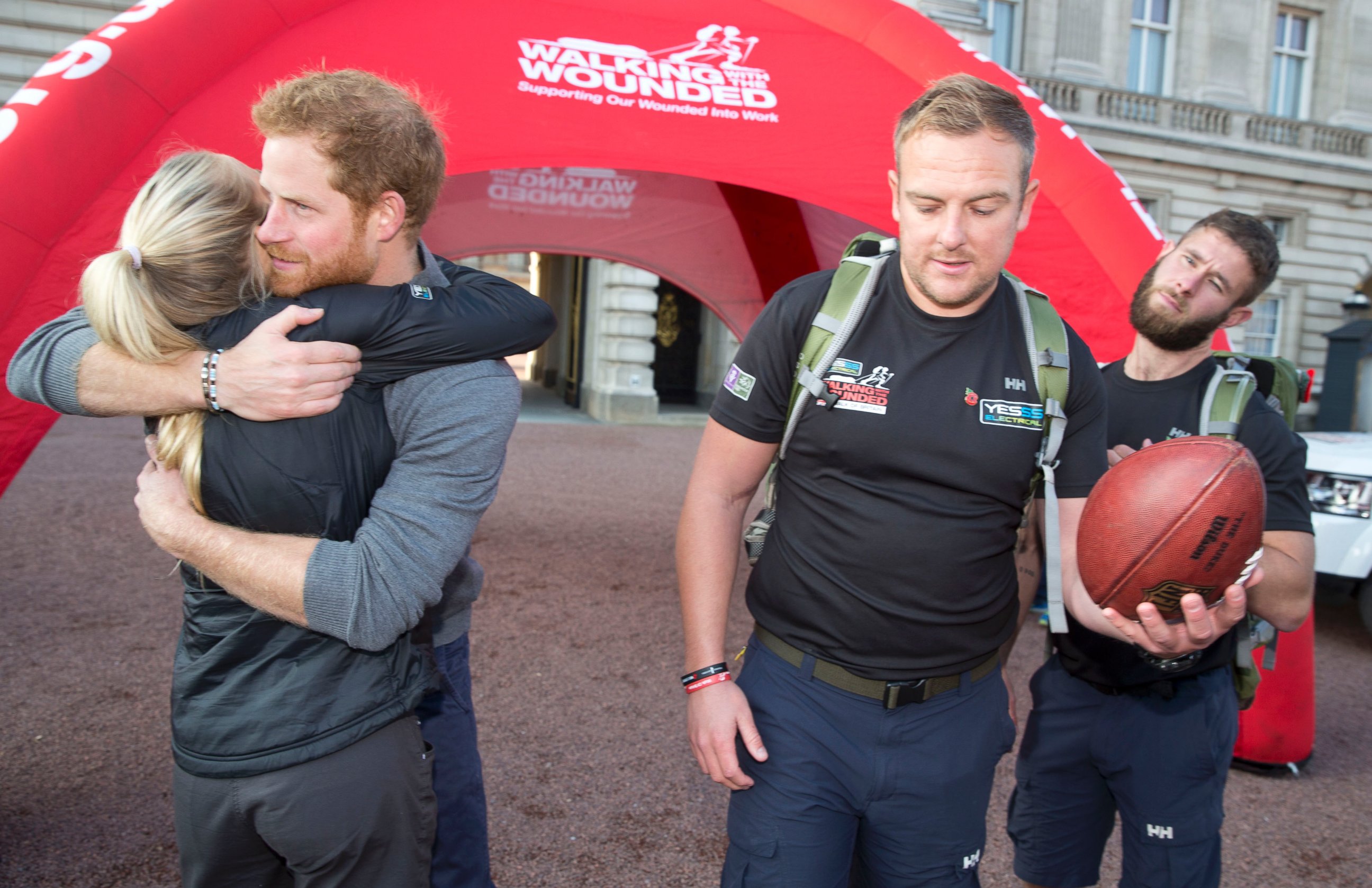 PHOTO: Prince Harry hugs Kirsty Ennis, a helicopter door gunner and Afghan veteran as he meets with members of the Walking With The Wounded team at Buckingham Palace, Nov. 1, 2015 in London.
