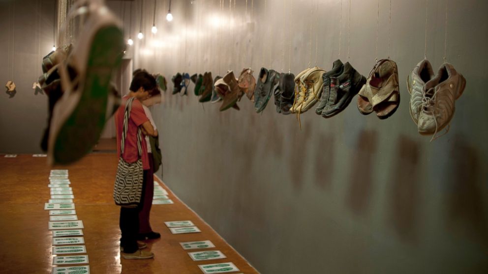 PHOTO: People look shoes of missing people with messages printed on their soles hanging from the roof of the "Casa de la Memoria Indomita" museum during the opening of the "Huellas de La Memoria" (Memory Tracks) exhibition in Mexico City, May 9, 2016. 