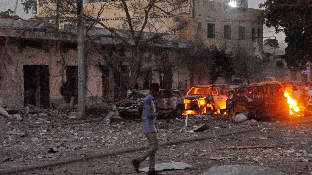 PHOTO: A man walks past the scene after a car bomb exploded, June 1, 2016, outside a Mogadishu hotel that houses several MPs, killing several people, and followed by a gun battle.