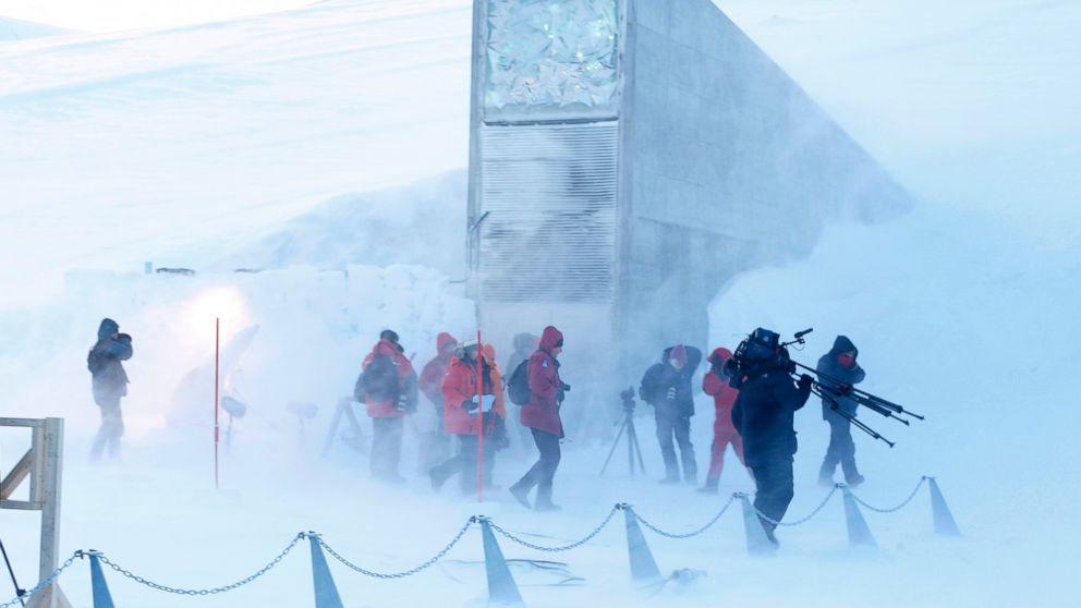 Journalists and cameramen walk under a gust of cold wind near the entrance of the Svalbard Global Seed Vault that was officially opened near Longyearbyen, Norway, Feb. 26, 2008. 