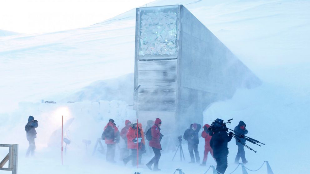 Journalists and cameramen walk under a gust of cold wind near the entrance of the Svalbard Global Seed Vault that was officially opened near Longyearbyen, Norway in this Feb. 26, 2008 file photo. 