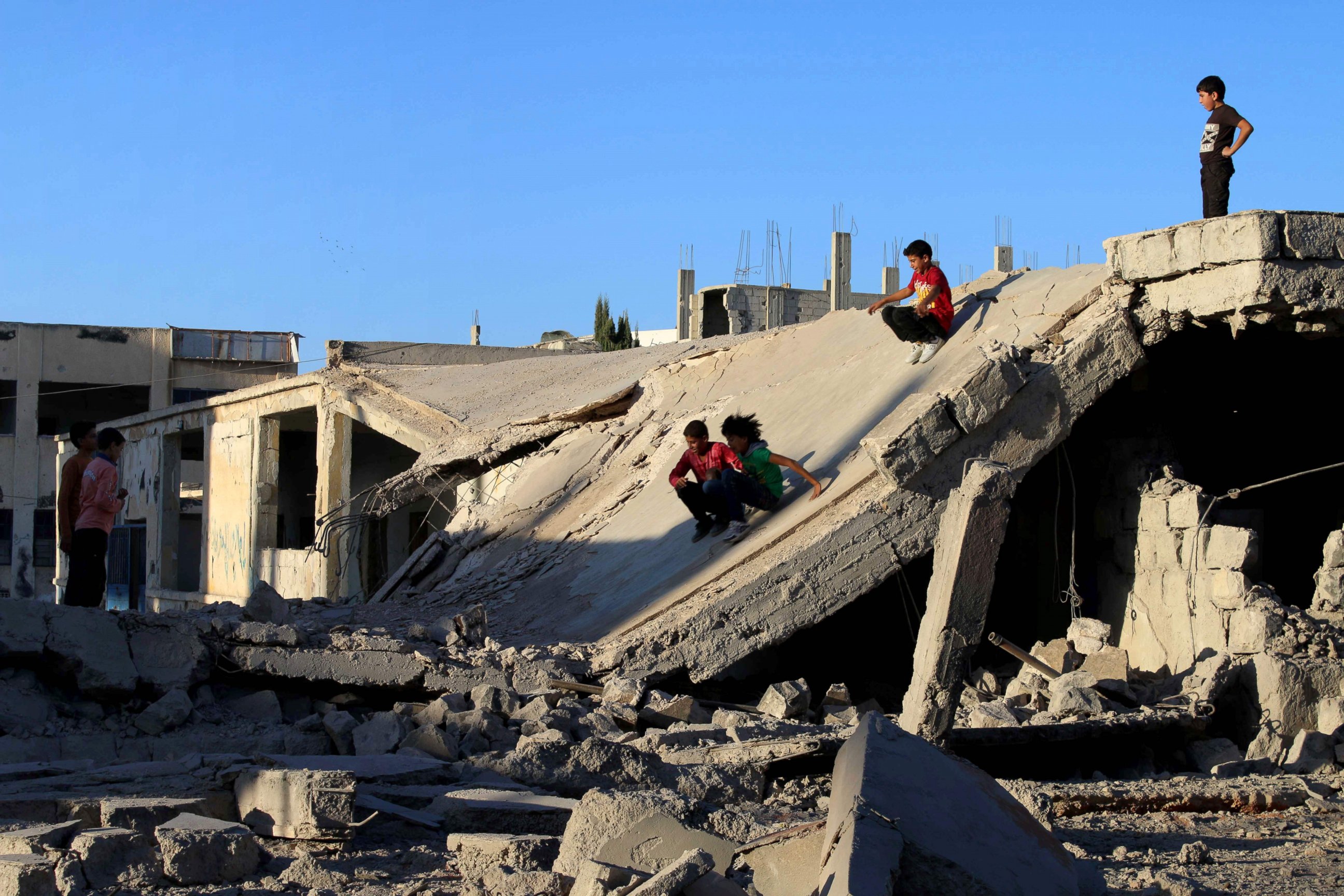 PHOTO: Syrian children slide down rubble of a destroyed building in the rebel-held city of Daraa, Syria, Sept. 12, 2016.