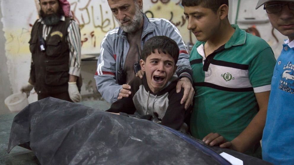 PHOTO: A Syrian boy is comforted as he cries next to the body of a relative who died in a reported airstrike on April 27, 2016 in the rebel-held neighborhood of al-Soukour in the northern city of Aleppo.