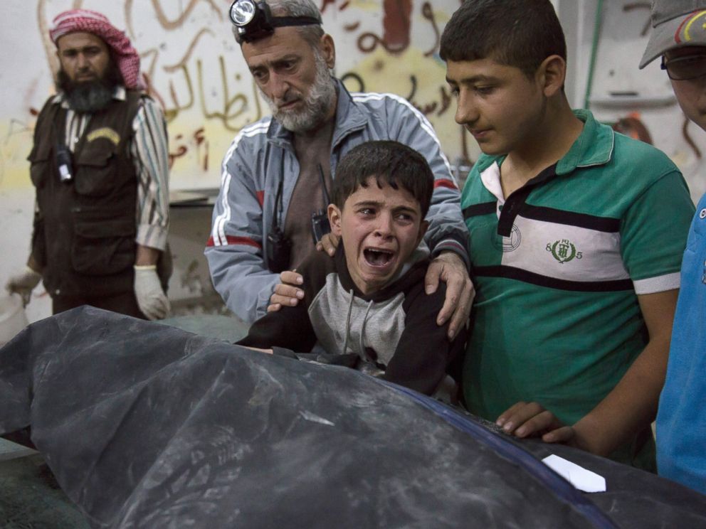 PHOTO: A Syrian boy is comforted as he cries next to the body of a relative who died in a reported airstrike on April 27, 2016 in the rebel-held neighborhood of al-Soukour in the northern city of Aleppo.