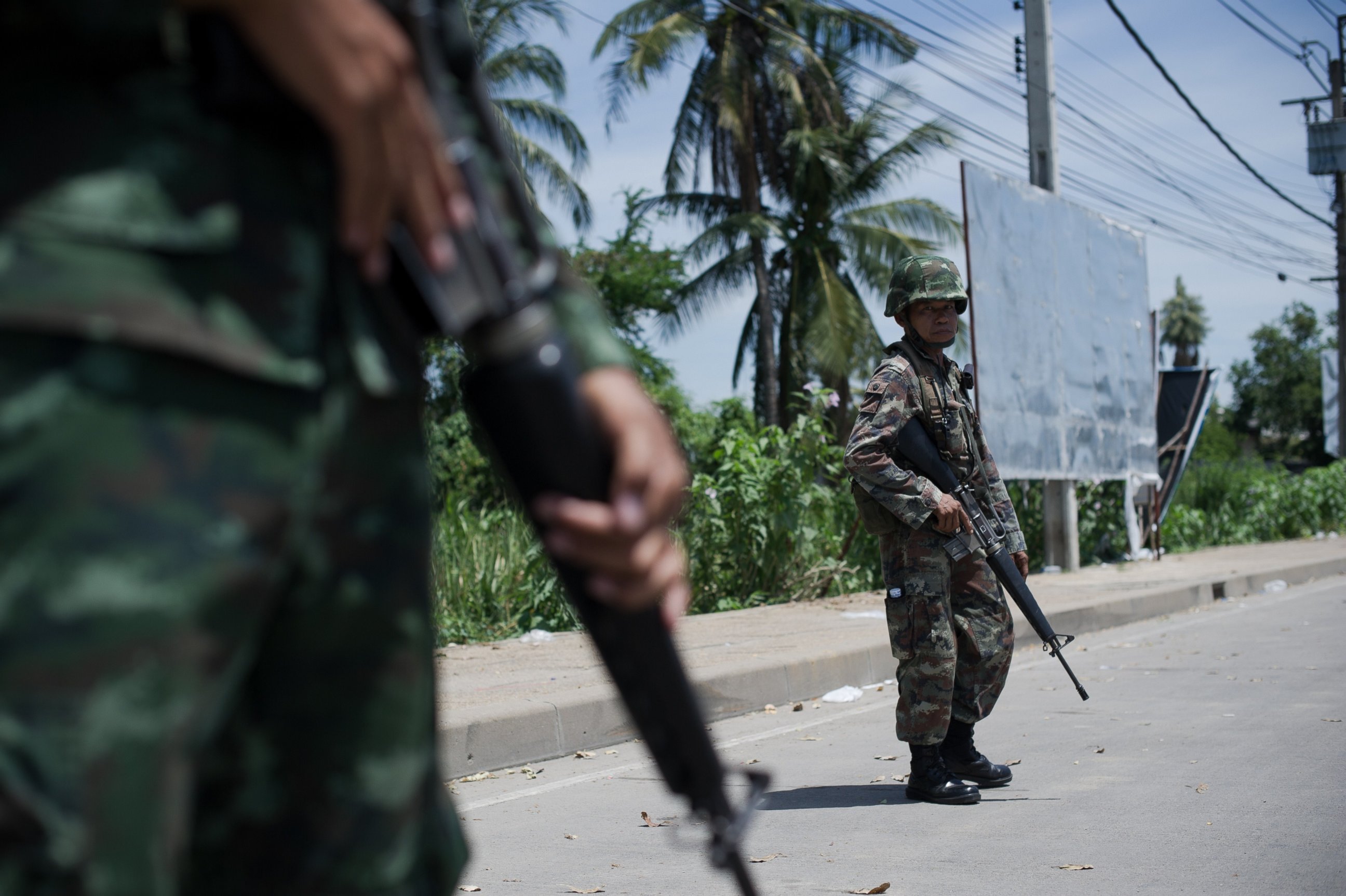 PHOTO: Thai army soldiers stand at a checkpoint near where pro-government ''Red shirts'' have been rallying for days on the outskirts of Bangkok on May 20, 2014. 