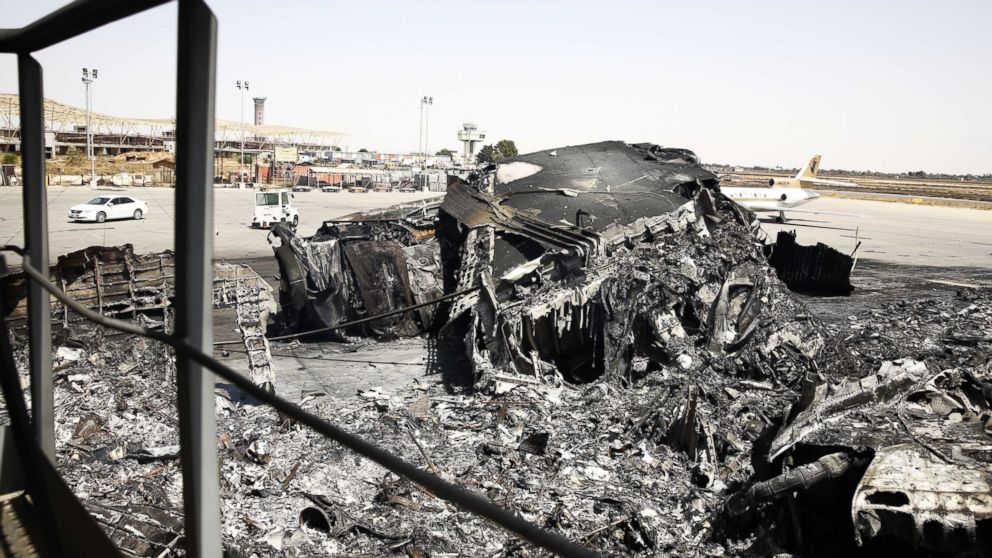 A burnt airplane lies at Tripoli international airport in the Libyan capital on July 21, 2014, after militias stepped up their assault on the country's main airport.