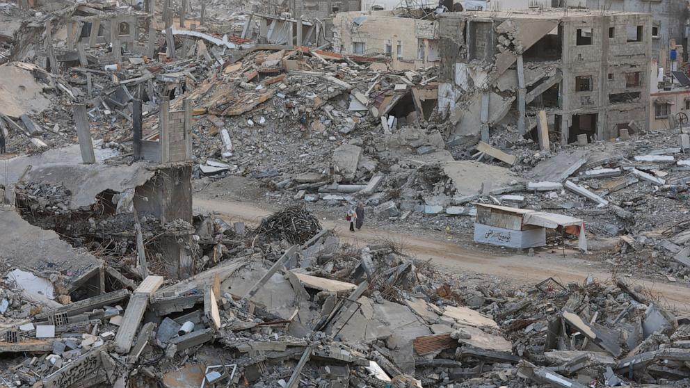 PHOTO: Palestinian women walk among piles of rubble and damaged buildings, in Gaza City, on Nov. 24, 2025.