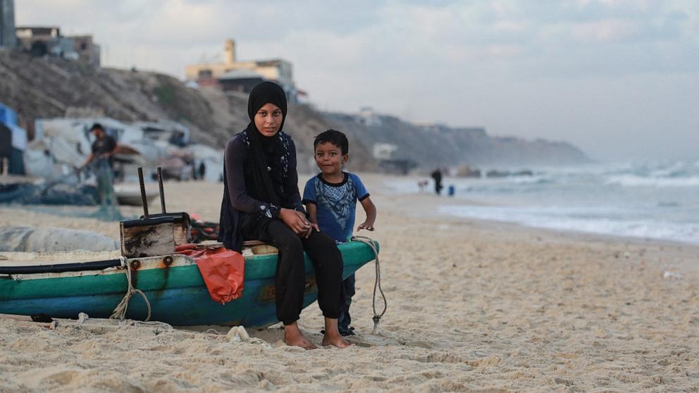 PHOTO: Displaced Palestinians sit on a fishing boat along the shore in Deir el-Balah in the central Gaza Strip, on Oct. 5, 2025.