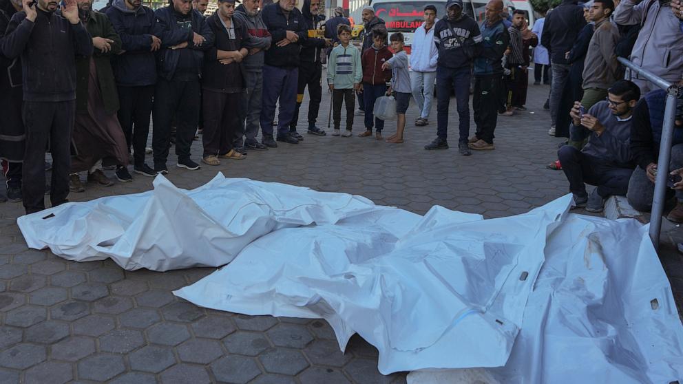 PHOTO: Men pray over the bodies of victims of an Israeli airstrike outside the Al-Aqsa Martyrs hospital in Deir al-Balah, Gaza Strip, on Dec. 21, 2024.