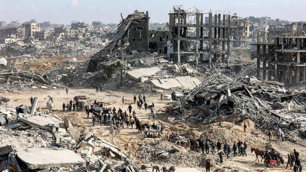 PHOTO: People walk past the rubble of collapsed buildings along Saftawi Street in Jabalia in the northern Gaza Strip on Jan. 20, 2025.