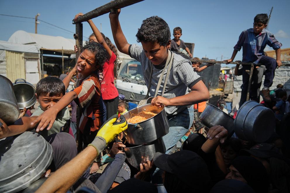 PHOTO: Palestinians gather for food at a community kitchen in Khan Younis, in the southern Gaza Strip, on Oct. 5, 2025.