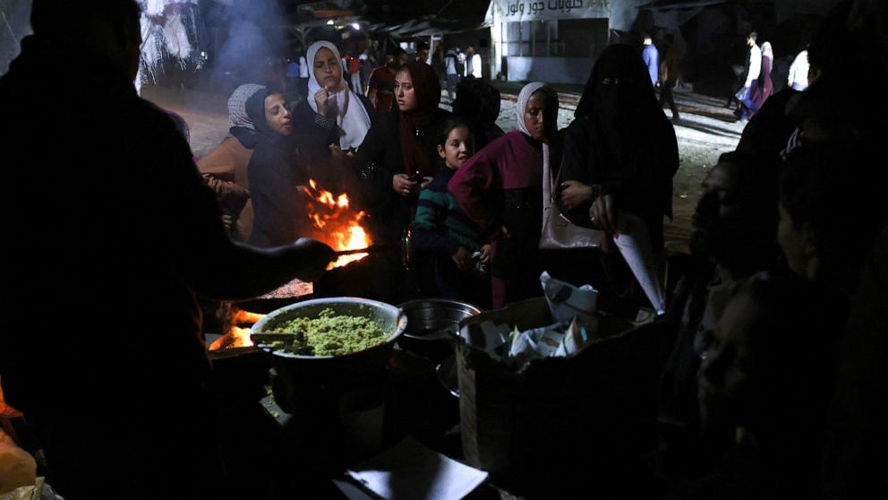 PHOTO: People wait for food in a makeshift displacement camp in Khan Younis in southern Gaza on Nov. 11, 2024.