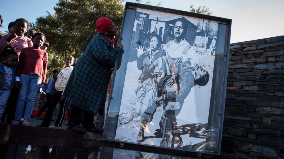 Ms. Nontsikelelo Makhubu is seen next to the iconic photograph by Sam Nzima showing Hector Pieterson being carried away during the start of the Soweto Uprising in 1976, during celebrations to commemorate the 40th anniversary, June 16, 2016, in Soweto, South Africa. 
