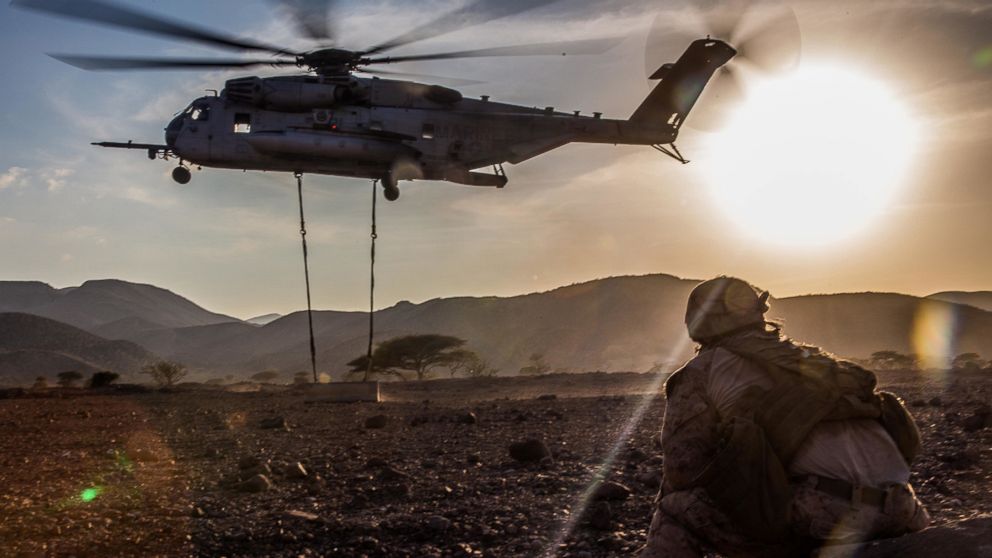 A Marine with the 11th Marine Expeditionary Unit watches as a CH-53E Super Stallion lifts a concrete barrier during helicopter external load training at Arta Beach, Djibouti, Feb. 16, 2017.
