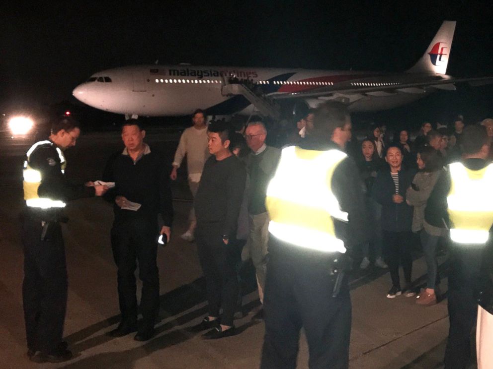 PHOTO: Passengers aboard Malaysian Airlines MH128 wait to speak with investigators after their Kuala Lumpur-bound flight was forced to return to Melbourne Airport because of a disruptive passenger.