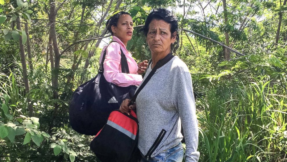 After crossing into Brazil, Marta and Liset wait nervously for the signal to run to awaiting cars.