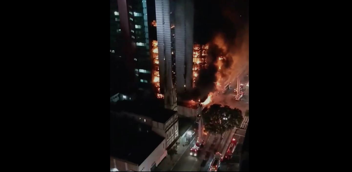 PHOTO: Video posted on social media early Tuesday showed a multi-story buildings crumbling upon itself as a fire raced towards the top floor.