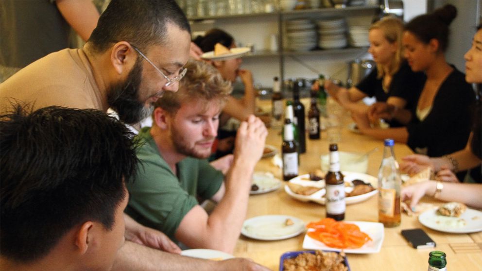 PHOTO: Refugees and Germans sharing a meal at a community kitchen event organized by Ueber den Tellerrand kochen -