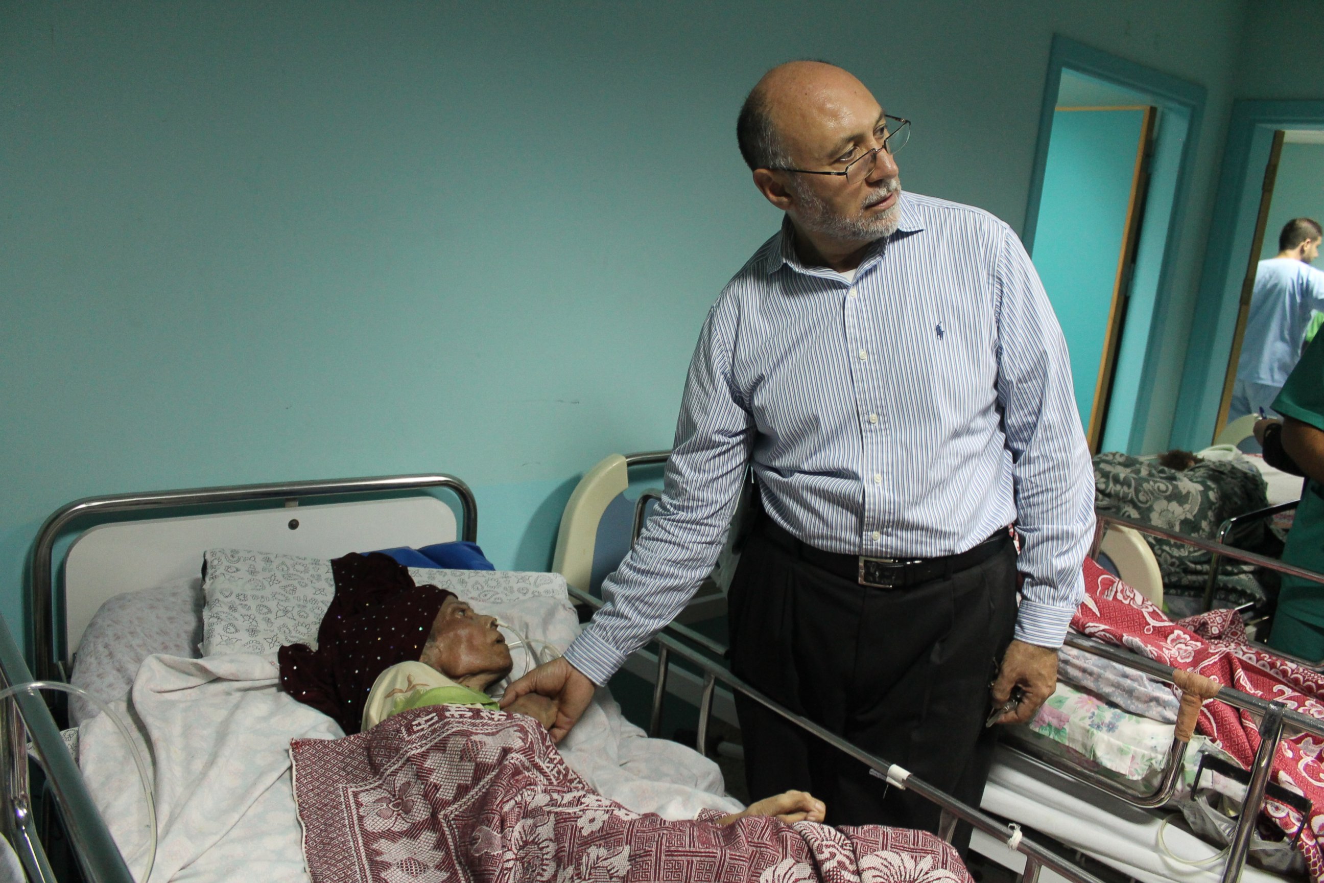 PHOTO: Basman Alashi, executive director of el-Wafa Hospital in eastern Gaza City, comforts a patient hours after an Israeli projectile struck the hospital's fourth floor Friday evening, demolishing a wall and damaging doors and windows. 
