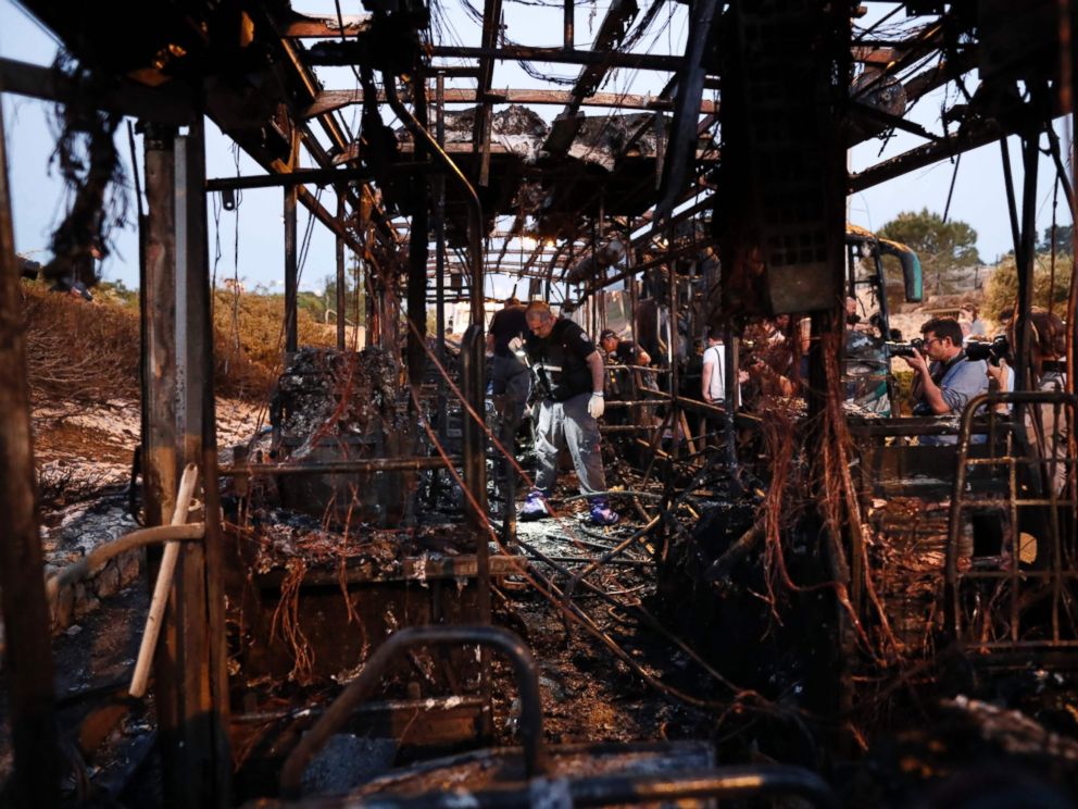 PHOTO: Israeli forensics search the remains of burnt-out bus following an explosion in Jerusalem, April 18, 2016.