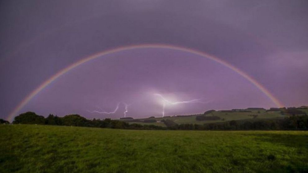 Ian Gendinning posted this photo to Instagram with the caption, "Full moon creating a rainbow with lightning framed in the background."