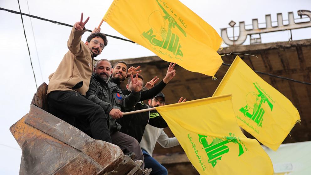 PHOTO: Men sitting in a bulldozer's bucket wave Hezbollah's flags as they celebrate a ceasefire between Israel and Hezbollah that went into effect on Nov. 27, 2024, in Zefta, southern Lebanon.