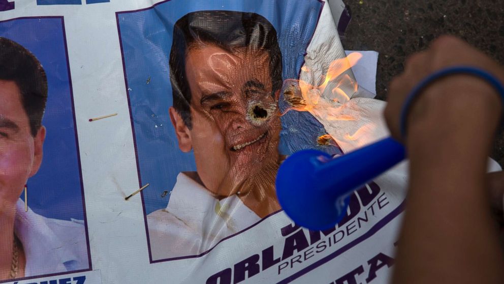 PHOTO: A banner promoting Honduran President Juan Orlando Hernandez burns after being set on fire by supporters of challenger Salvador Nasralla, during a protest march claiming electoral fraud, in Tegucigalpa, Honduras, Nov. 29, 2017. 