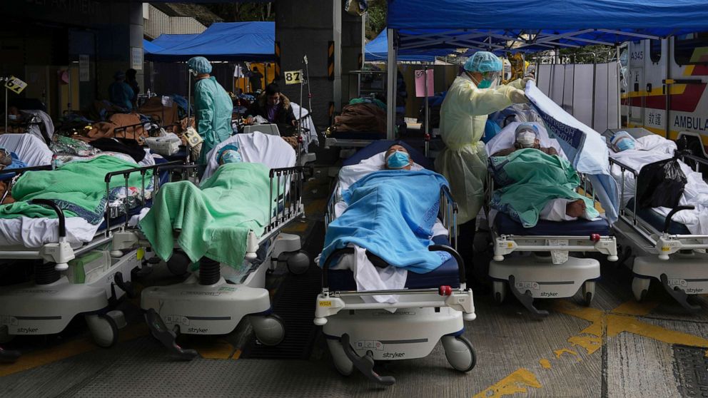 PHOTO: Patients lie on hospital beds as they wait at a temporary makeshift treatment area outside Caritas Medical Centre in Hong Kong, Feb. 18, 2022.