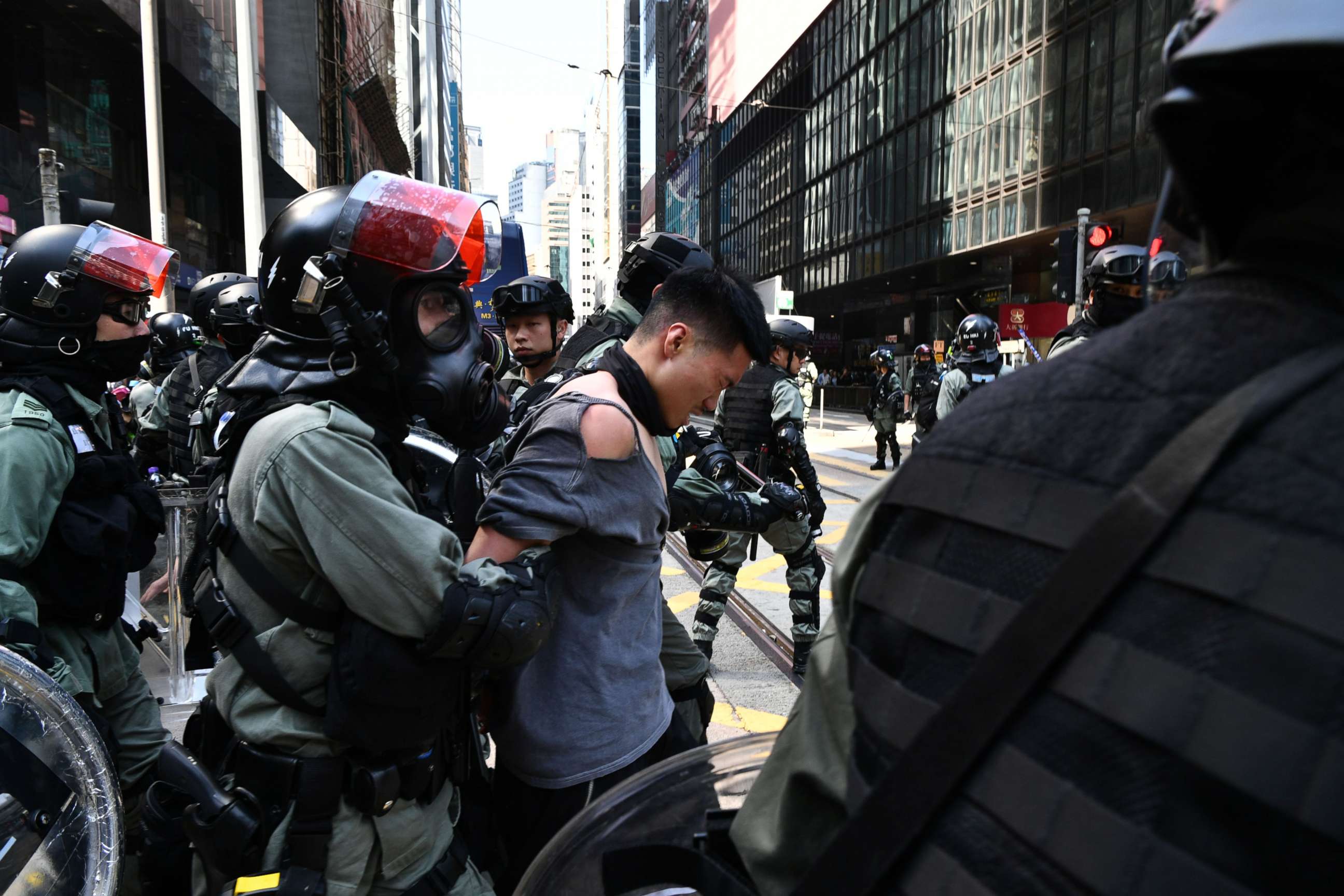 PHOTO: A man (C, in torn shirt) is detained by riot police during a protest in Hong Kong's Central district on November 11, 2019. (Photo by ANTHONY WALLACE/AFP via Getty Images)