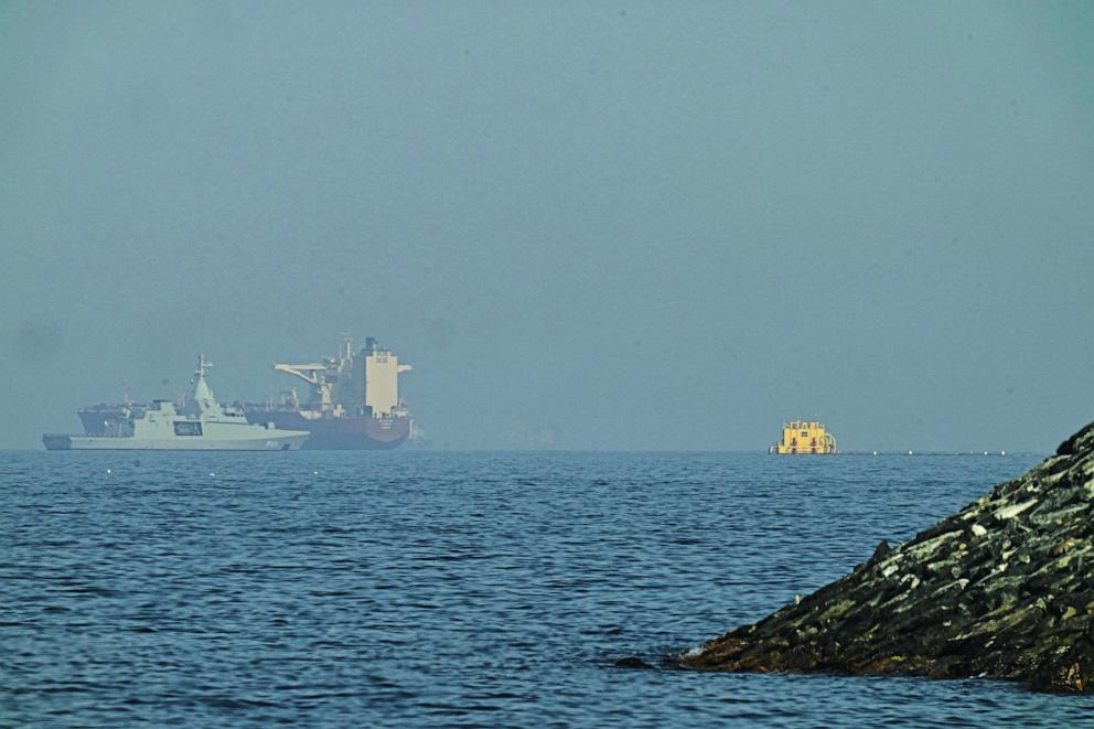 PHOTO: An Emirati patrol boat (L) is pictured near a tanker anchored in the Gulf of Oman near the Strait of Hormuz, as seen from a coastal road near Khor Fakkan, United Arab Emirates, on May 1, 2026.