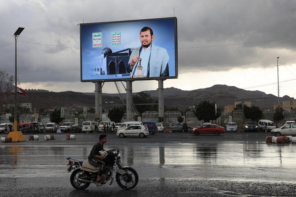 PHOTO: Vehicles pass under a banner showing Houthi leader Abdul Malik al-Houthi, in Sanaa, Yemen, on March 31, 2026.