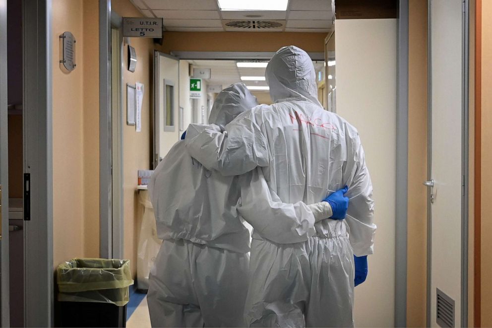 PHOTO: Dr. Marco (right) and nurse Manu, wearing protective gear, react at the end of their shift in a corridor of the level intensive care unit, treating COVID-19 patients, at the San Filippo Neri hospital in Rome, Italy, on April 20, 2020.