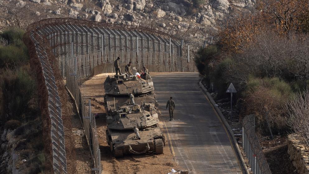 PHOTO: Israeli soldiers stand near tanks along the border with Syria on Dec. 9, 2024, in the occupied Golan Heights.