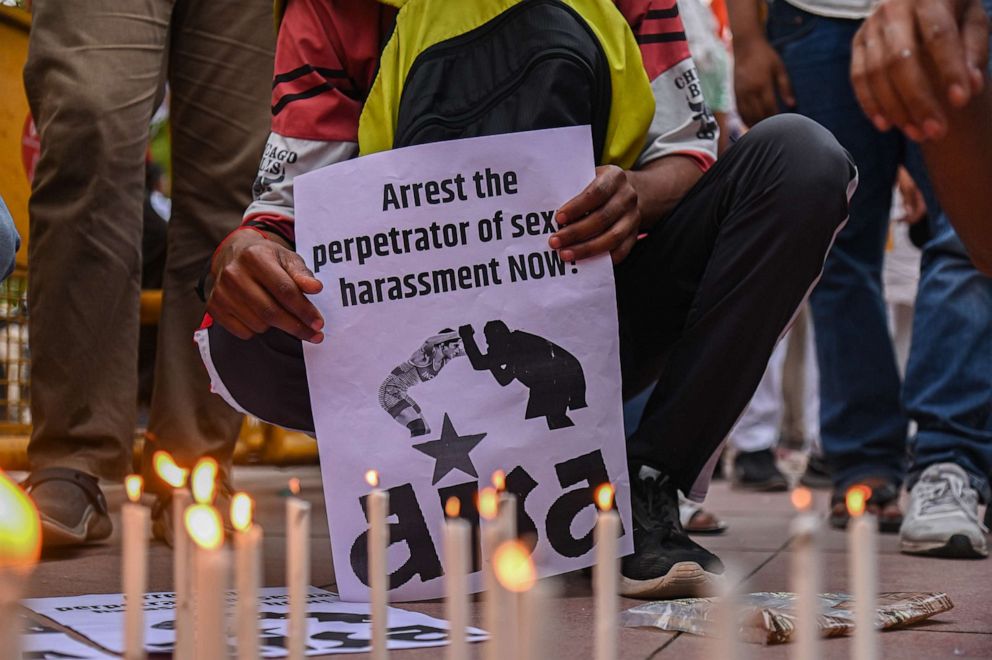 PHOTO: A person holds a placard during a Candlelight March called by Indias Top Wrestlers against the allegations of sexual harassment to athletes by the Wrestling Federation of India (WFI) chief, in New Delhi on May 23, 2023.