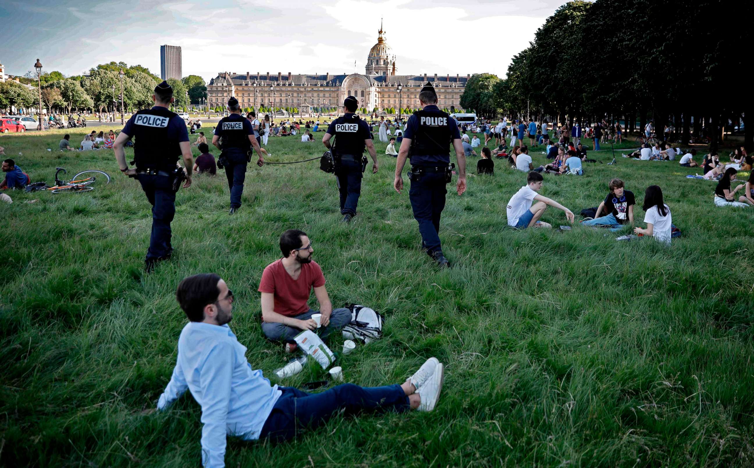 PHOTO: Police officers ask to People who enjoy a sunny day to keep their distance, in front of the hotel des Invalides in Paris, on May 21, 2020, as France eases measures taken to curb the spread of the COVID-19 disease caused by the novel coronavirus.